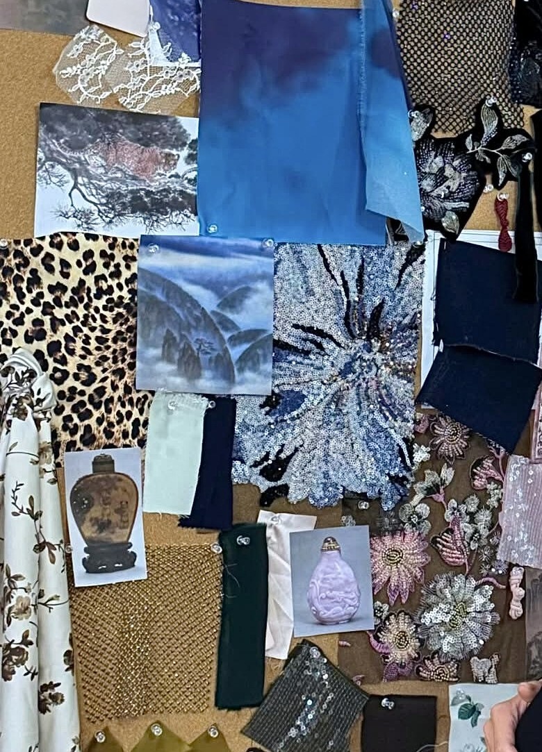 Design moodboard of fabric swatches, printed artwork and photographs pinned to a corkboard